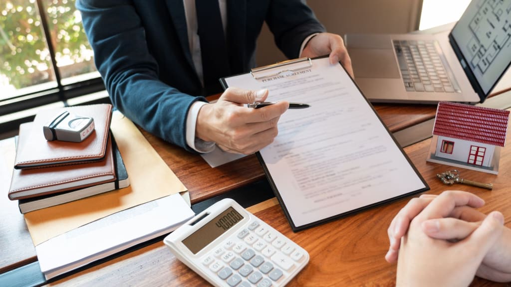 A person handing bank documents for house